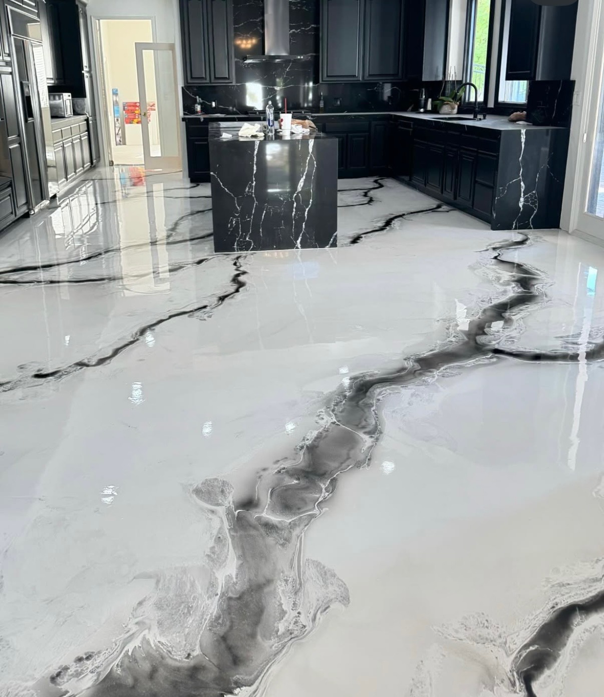 White kitchen floor with black and grey marble-look metallic epoxy