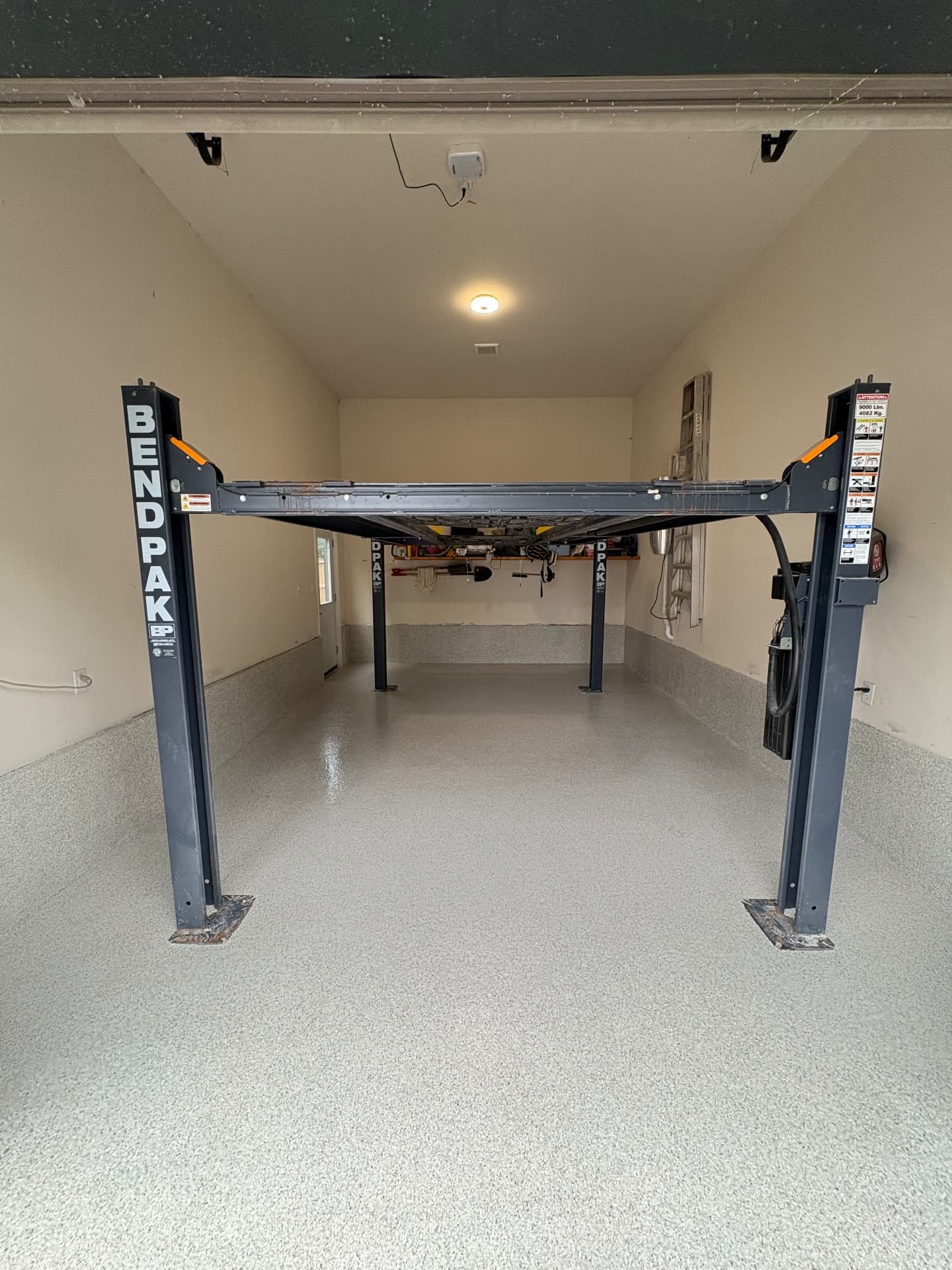 Light flake epoxy garage floor with a car lift