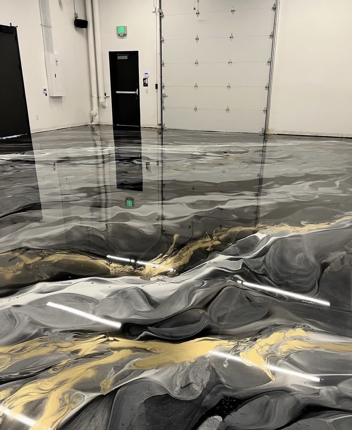 Black and gold metallic epoxy floor in a commercial shop